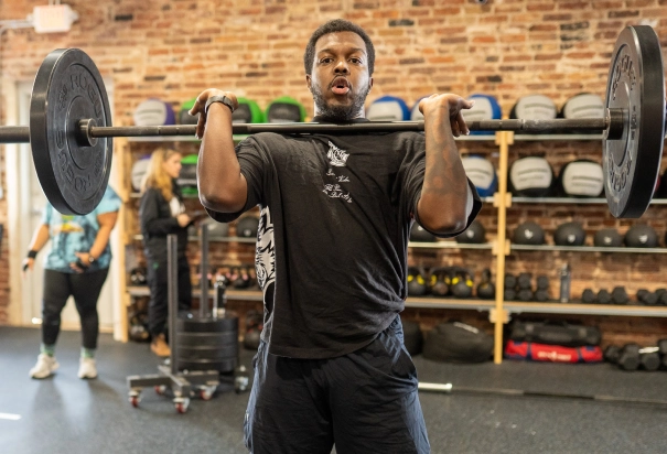 man in black shirt lift weight