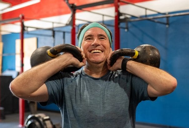 man with two kettlebells